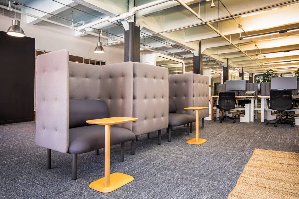 Office area featuring gray high-back booths designed for private work or meetings.