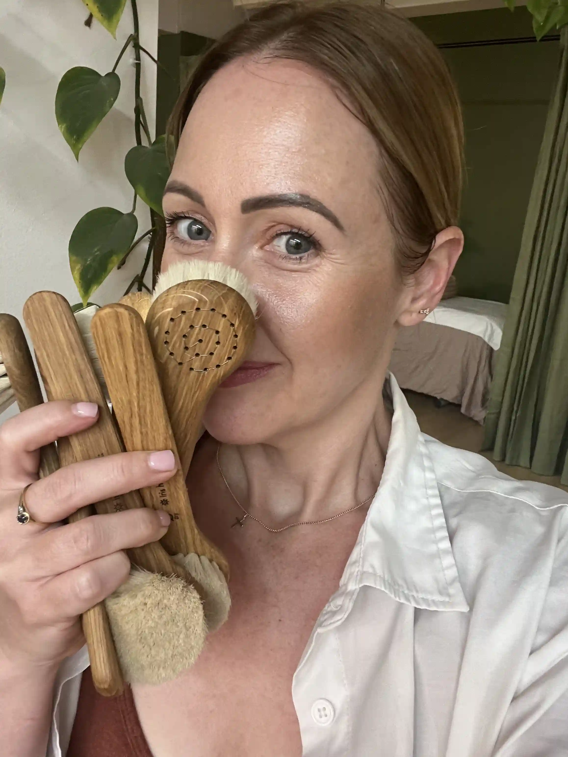 Business owner at Skinn enjoying the aroma of facial brushes, showcasing a commitment to natural skincare and a personalised touch in our About Us page