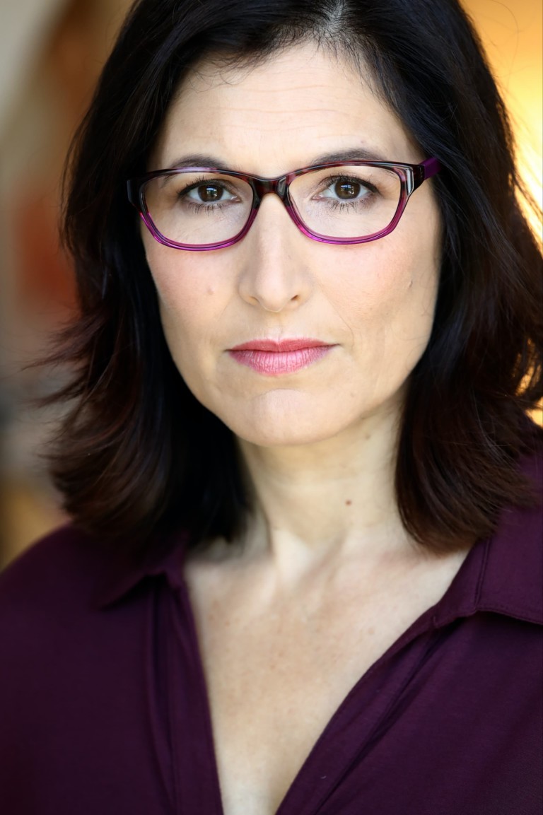 Image of Beth wearing glasses and a purple top